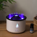 Difusor de aromas blanco con bruma iluminada en tonos azul y morado, junto a un frasco de aceite esencial